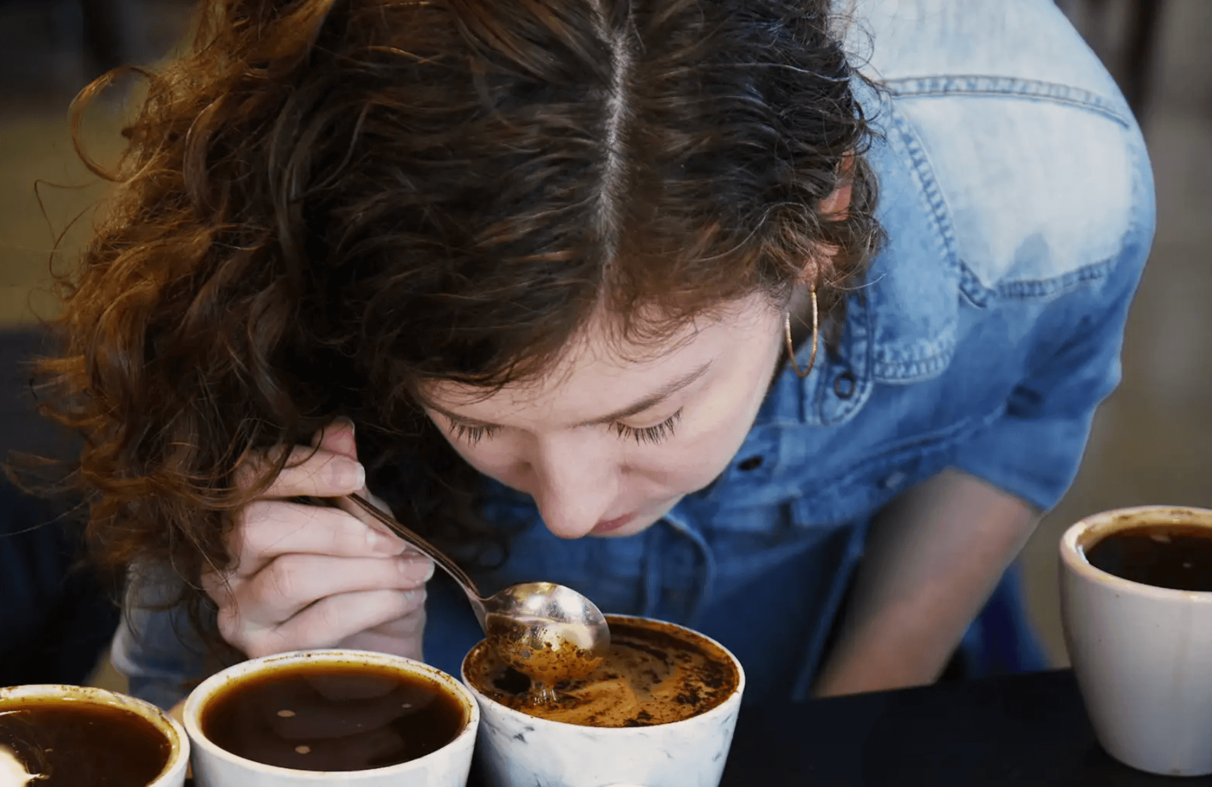 a woman smelling coffee