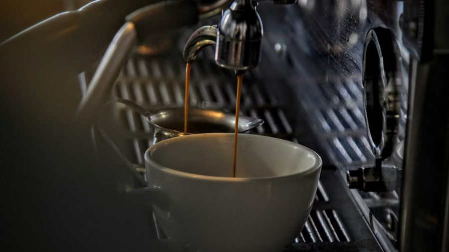 Espresso flowing from a machine into a cup